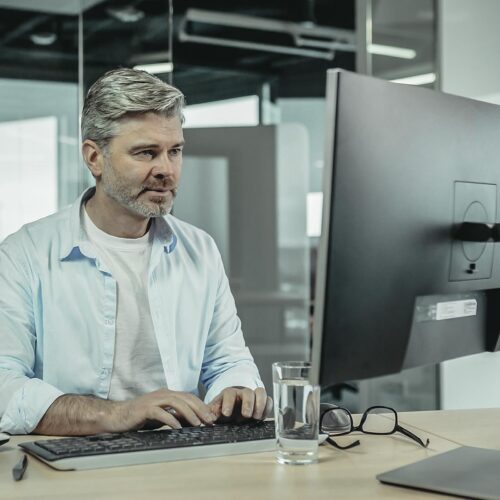 Midaldrende man arbejder med E-Learning på computer.