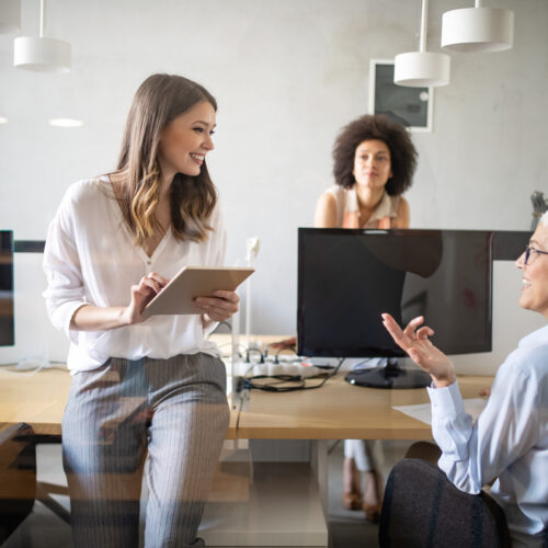Women in office space discussing E-Learning
