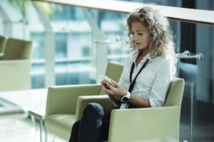 Professional reviewing information on her phone.
