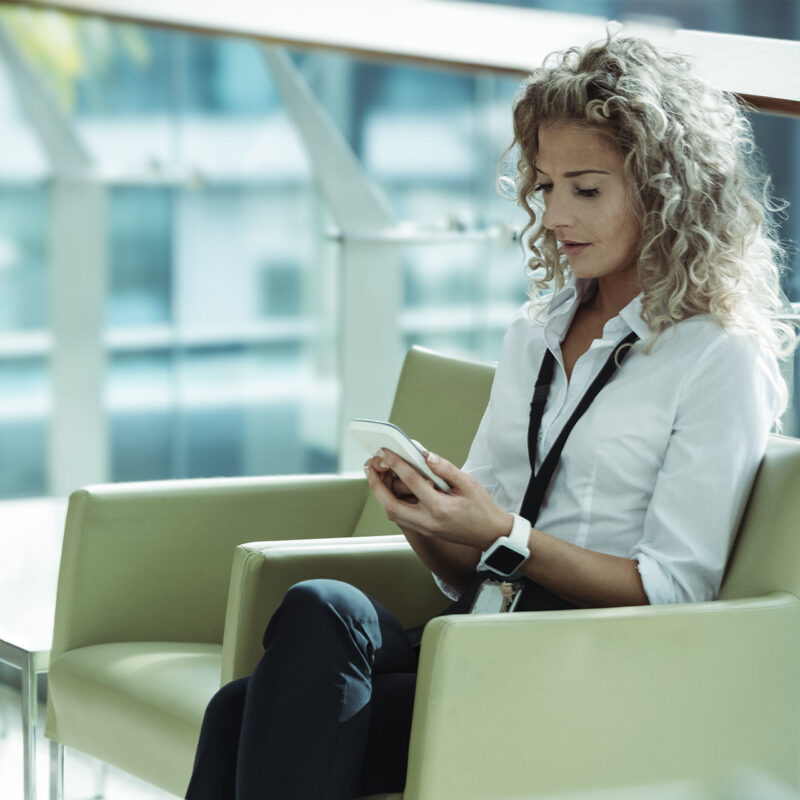 Professional reviewing information on her phone.
