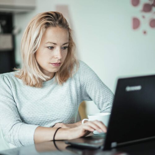 Kvinde bruger bærbar computer og deltager i AI awareness online kursus